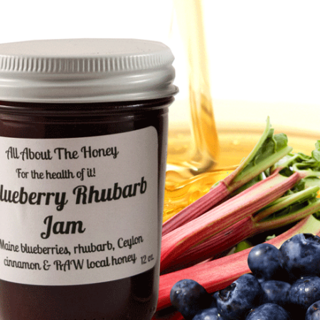 A jar of blueberry rhubarb jam next to some fruit.