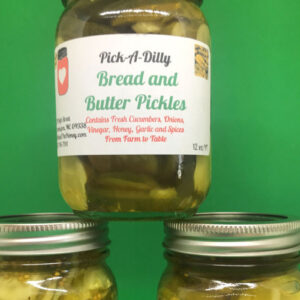 A jar of bread and butter pickles on top of green background.