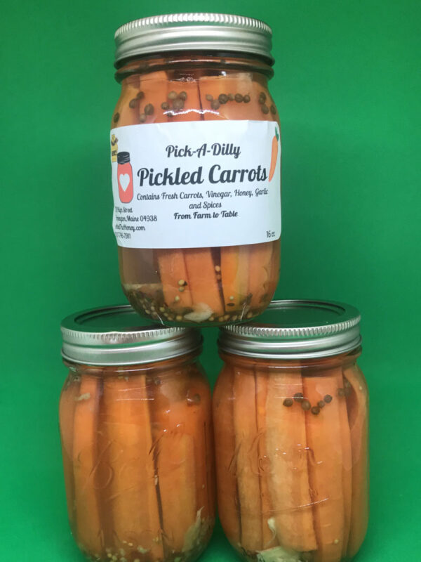 A jar of pickled carrots on top of three other jars.